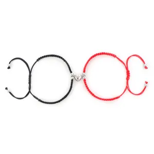 Vista dettagliata di bracciali di coppia intrecciati a mano con ciondoli a cuore magnetici.