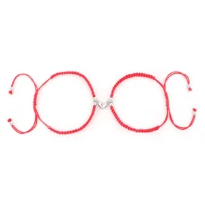 Primo piano dettagliato del braccialetto di coppia intrecciato rosso con chiusura magnetica.