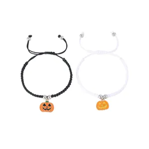 Close-up details of the handmade woven couple bracelet with a cute pumpkin charm.