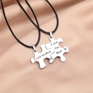Stainless steel puzzle couple necklace detail shot, matching black leather cords and sweet engraving.