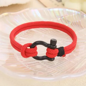 Détail de bracelet en corde Milan rouge avec fermoir menotte en acier noir.