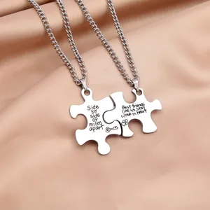 Stainless steel puzzle couple necklace detail showcasing engraved friendship text design.