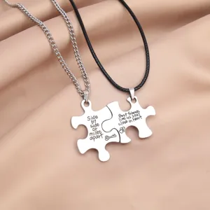 Stainless steel puzzle piece pendant necklace detail showing engraved friendship love quotes.