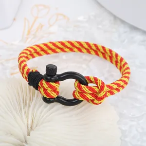 Vue détaillée bracelet en corde tissée rouge et jaune avec manille noire homme.