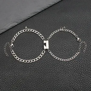 Vista detallada de pulseras de pareja de acero inoxidable con cierre de corazón magnético.