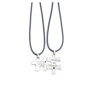 Detail shot of matching puzzle couple necklaces with engraved sweet quotes and black cord.