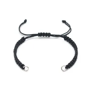 Detailed shot of a black handmade braided cord bracelet with adjustable sliding knot and steel rings.