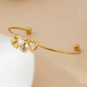 Bracelet en acier inoxydable doré avec pendentif cœur amour et détail de cristal.