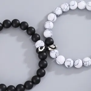 Vista dettagliata del bracciale di coppia in perle opache e turchese bianco con cuore.