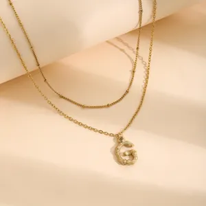 Elegante collana doppia dorata con ciondolo a lettera G testurizzato a bambù.