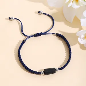 Dettaglio del bracciale intrecciato blu scuro fatto a mano con pietra di tormalina nera.