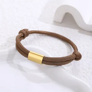 Handmade braided brown paracord bracelet detail featuring a smooth gold stainless steel tube.