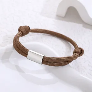 Close-up detail of handmade brown paracord bracelet with blank stainless steel tube for engraving.