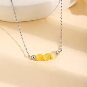 Collier de chaîne en acier inoxydable avec perles d'œil de chat jaunes et détails argentés.