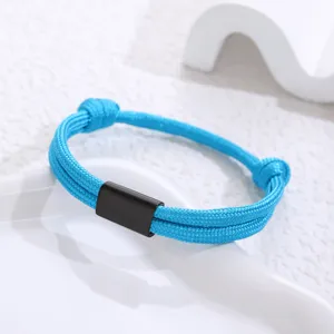 Detail shot of blue paracord bracelet with black stainless steel clasp element close up.