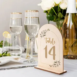 Wooden arched table number sign detail featuring elegant foliage for wedding table decor.