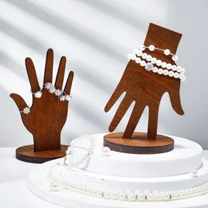 Close-up detail of wooden hand jewelry display stand with elegant pearl bracelets and rings.