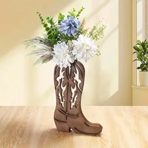 Detalle de jarrón bota de vaquero de madera, arreglo floral rústico de escritorio.