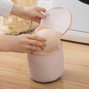 Sac de lavage rose cylindrique pour soutiens-gorge avec filet fin et fermeture eclair