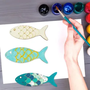 Gros plan de découpes de poissons en bois non finis avec motifs d'écailles pour loisirs créatifs.