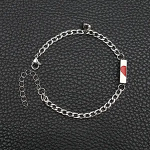 Detalle en primer plano de pulsera de pareja magnética de acero inoxidable con medio corazón.