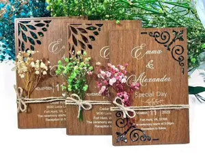 Wooden wedding invitation card detail showing laser cut pattern, twine bow and dried floral.