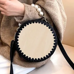 Detail view of a creative handmade round wooden bag bottom with pearl handle and shoulder strap.