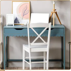 Moderno escritorio azul verdoso con borde festoneado y silla de madera blanca para estudio.