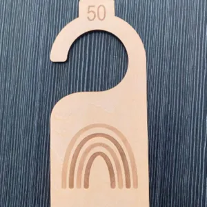 Wooden baby closet divider with rainbow engraving and size 50 marker for nursery organization.