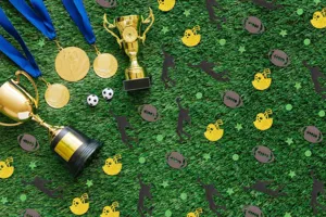 Sports party decoration set featuring gold trophies, medals, football confetti and team props.