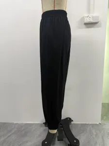 Vue détaillée latérale d'un pantalon sarouel noir ample à taille élastique.