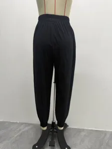 Pantalon harem décontracté noir pour femme avec taille élastique et ourlet resserré souple.