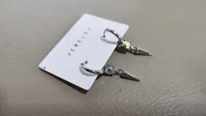 Stylish silver hoop earrings with sparkling rhinestones and cool metal spike pendants.