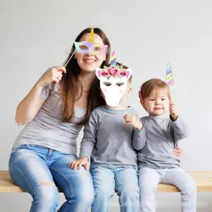 Detailansicht von Kindern, die süße Einhorn-Foto-Requisiten auf einer Geburtstagsfeier halten.