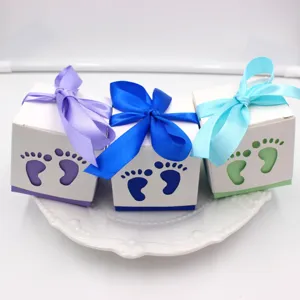Baby shower favor boxes with hollow footprints and ribbons, perfect for party gift packaging.