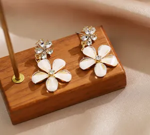 Vue détaillée de boucles d'oreilles élégantes marguerites blanches avec des strass brillants.