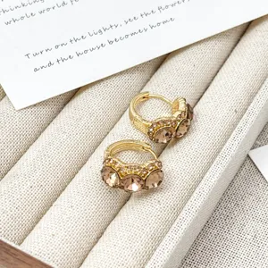 Nahaufnahme von vintage vergoldeten Strass Ohrringen mit Champagner Kristallen im Display.
