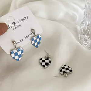 Close-up detail of blue and black checkerboard heart earrings with S925 silver posts.