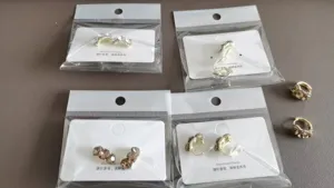 Nahaufnahme von Strasskristall-Ohrringen und Clip-Ohrringen auf Displaykarten in Verpackung.