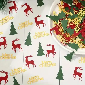 Nahaufnahme von Weihnachtskonfetti mit roten Rehen, grünen Bäumen und goldenem Merry Christmas.