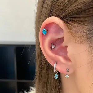 Exquisite multi-piercing earring set featuring blue teardrop pendants and chic orb design.