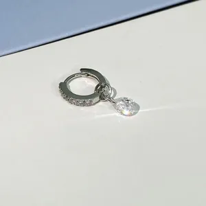 Detailed close-up of a sparkling paved hoop earring with a dangling teardrop crystal pendant.