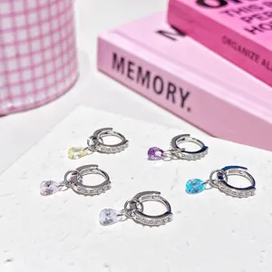 Detailed close-up of exquisite colorful teardrop crystal charm hoop earrings with shimmering stones.