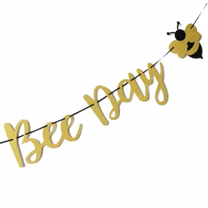 Primo piano dettagliato dello striscione con lettere Bee Day glitterate oro per feste.