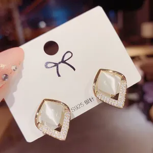 Detailed view of geometric cat-eye rhinestone earrings featuring S925 silver pins on card.