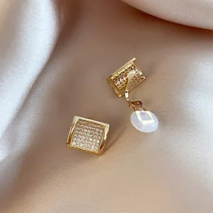 Detailed view of gold square rhinestone clip earrings showcasing paved crystal sparkle.