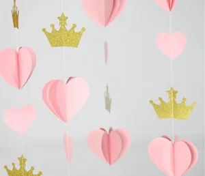 Dettaglio festone carta cuore rosa e corona dorata, decorazione sospesa per festa nozze.