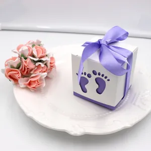 Detailed view of white favor box with purple bow and baby foot cutout for celebration.