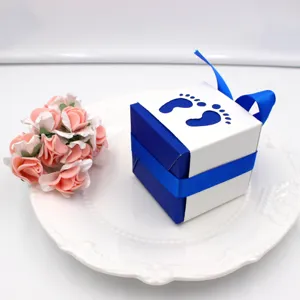 Blue and white baby shower candy box detail with footprint cutout and cute ribbon bow decoration.