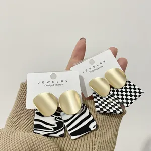 Matte gold and black white checkerboard zebra pattern acrylic statement fashion earrings.